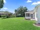 Lush backyard featuring a screened-in porch, well-maintained lawn and mature trees at 17427 Se 72Nd Overbrook Ct, The Villages, FL 32162