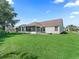 Spacious backyard showcasing a screened porch, manicured lawn and lush landscaping at 17427 Se 72Nd Overbrook Ct, The Villages, FL 32162