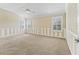 Large bedroom featuring neutral carpet, shutters, and a decorative wainscoting, offering comfort and style at 17427 Se 72Nd Overbrook Ct, The Villages, FL 32162