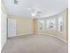 Bright bedroom featuring neutral carpet, large windows, and a ceiling fan for comfort at 17427 Se 72Nd Overbrook Ct, The Villages, FL 32162