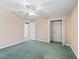 Cozy bedroom featuring neutral carpet, closet, ceiling fan, and ample space at 17427 Se 72Nd Overbrook Ct, The Villages, FL 32162