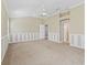 Spacious bedroom with a tray ceiling, neutral carpet, and stylish wainscoting, creating a calming retreat at 17427 Se 72Nd Overbrook Ct, The Villages, FL 32162