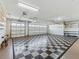 Spacious garage with a checkerboard floor, storage, and ample room for parking at 17427 Se 72Nd Overbrook Ct, The Villages, FL 32162