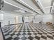 Expansive garage with checkerboard flooring, shelving, and cabinets for optimal storage at 17427 Se 72Nd Overbrook Ct, The Villages, FL 32162