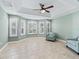 Bright living room featuring tray ceilings, tiled floors, and multiple windows with plantation shutters at 17427 Se 72Nd Overbrook Ct, The Villages, FL 32162