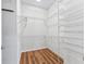 Well-organized walk-in closet featuring custom shelving and wood flooring for ample storage at 17427 Se 72Nd Overbrook Ct, The Villages, FL 32162