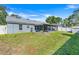The backyard features a screened lanai, a well-maintained lawn, and a privacy fence at 1761 Country Terrace Ln, Apopka, FL 32703