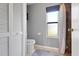 This bathroom features a toilet, window with blinds, tiled floors and a door to the stand-up shower at 1761 Country Terrace Ln, Apopka, FL 32703