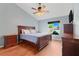 Well-lit bedroom featuring wood floors, ceiling fan, a dresser, and a large window at 1761 Country Terrace Ln, Apopka, FL 32703