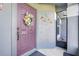A close up of the front door adorned with a floral wreath and artistic lizard decor at 1761 Country Terrace Ln, Apopka, FL 32703