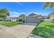 A shot of the right side of the home showing the two car garage and mature landscaping at 1761 Country Terrace Ln, Apopka, FL 32703