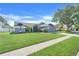 A side angle shot of the front of the home with manicured lawn, mature landscaping at 1761 Country Terrace Ln, Apopka, FL 32703