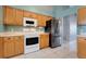 This kitchen includes bright, wooden cabinetry, stainless steel appliances, and tiled floors at 1761 Country Terrace Ln, Apopka, FL 32703