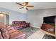 Inviting living room with comfortable furnishings, a ceiling fan, and entertainment center for modern living at 1761 Country Terrace Ln, Apopka, FL 32703