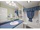 Well-lit bathroom with blue accents, wallpaper, and a combined shower and tub at 17800 Se 91St Gaylark Ave, The Villages, FL 32162