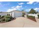 A well-kept one-story home featuring a two-car garage, driveway, well-maintained lawn, and white picket fence at 17800 Se 91St Gaylark Ave, The Villages, FL 32162
