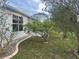 Home exterior with a screened lanai, landscaped yard, and well-maintained siding and trimming at 1812 Sanibel Ct, The Villages, FL 32162