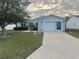 Charming single-story home featuring a well-manicured lawn, driveway, and attached garage at 1812 Sanibel Ct, The Villages, FL 32162