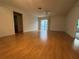 Spacious living room featuring hardwood floors and sliding glass doors to a screened patio at 1812 Sanibel Ct, The Villages, FL 32162