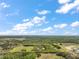 Stunning aerial shot of property bordered by lush trees, revealing its size and setting under a blue sky at 19621 Lake Lincoln Ln, Eustis, FL 32736