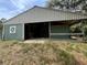 Exterior view of the green barn featuring metal roof and open bays providing sheltered space and rustic charm at 19621 Lake Lincoln Ln, Eustis, FL 32736