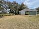 Exterior of barn with sliding door and green and white trim, situated on a grassy field with surrounding trees at 19621 Lake Lincoln Ln, Eustis, FL 32736