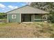 Green barn featuring metal roof with an open bay and enclosed stall area, perfect for equestrian enthusiasts at 19621 Lake Lincoln Ln, Eustis, FL 32736