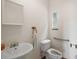 Small bathroom with a pedestal sink, window, toilet, and accessibility bar at 19621 Lake Lincoln Ln, Eustis, FL 32736