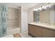 Bathroom with a double sink vanity, marble countertop, and a shower-tub combo at 19621 Lake Lincoln Ln, Eustis, FL 32736