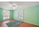 Bright bedroom with wood flooring, large windows, and a green accent wall at 19621 Lake Lincoln Ln, Eustis, FL 32736