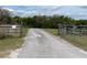 Gated entrance to a driveway surrounded by lush trees and foliage at 19621 Lake Lincoln Ln, Eustis, FL 32736