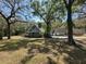 Two-story home featuring a covered porch with mature trees providing shade to the large front lawn at 19621 Lake Lincoln Ln, Eustis, FL 32736
