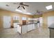 Spacious eat-in kitchen with white cabinetry, a center island with stone countertops and tile flooring at 19621 Lake Lincoln Ln, Eustis, FL 32736