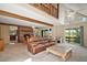 Open concept living room with brick fireplace, exposed wood beams, and a leather sofa at 19621 Lake Lincoln Ln, Eustis, FL 32736