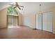 Large living room with high ceilings, a ceiling fan, and sliding door to a balcony at 19621 Lake Lincoln Ln, Eustis, FL 32736