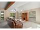 Living room with high ceilings, a ceiling fan, large windows, and a leather couch at 19621 Lake Lincoln Ln, Eustis, FL 32736