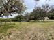 Picturesque view of a sprawling property featuring mature trees, lush greenery, and charming buildings at 19621 Lake Lincoln Ln, Eustis, FL 32736