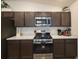 Well-equipped kitchen with dark cabinets, stainless steel appliances, and stylish countertops at 1978 Lockett Ln, The Villages, FL 34762