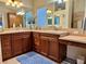 Spacious bathroom featuring double sinks, ample counter space, and warm wood cabinetry at 1985 Abordale Ln, The Villages, FL 32162