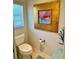 Bathroom featuring a white toilet, framed floral art, and window with blinds at 1985 Abordale Ln, The Villages, FL 32162