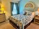 Bright bedroom featuring a queen bed, patterned bedding, and decoratively framed headboard at 1985 Abordale Ln, The Villages, FL 32162
