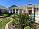 Manicured front yard with lush landscaping and a charming home name sign for a welcoming appeal at 1985 Abordale Ln, The Villages, FL 32162