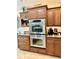 Gourmet kitchen with stainless steel double ovens and custom wood cabinetry at 1985 Abordale Ln, The Villages, FL 32162