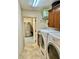 Functional laundry room with front-load washer and dryer, cabinets, and access to the stainless steel refrigerator at 1985 Abordale Ln, The Villages, FL 32162