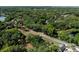Aerial view of the property surrounded by trees, located near a road with views of a neighborhood at 201 W Mirror Lake Dr, Fruitland Park, FL 34731