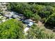 Aerial view of a home with a long drive, green surroundings, and car port at 201 W Mirror Lake Dr, Fruitland Park, FL 34731