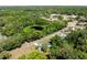 Aerial view of the property showcasing its location surrounded by trees, with a pond nearby at 201 W Mirror Lake Dr, Fruitland Park, FL 34731