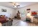 Cozy bedroom with a ceiling fan, light gray wood-look flooring, and natural light from the window at 201 W Mirror Lake Dr, Fruitland Park, FL 34731