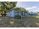 One-story home with a metal carport, showcasing a well-maintained exterior and mature landscaping at 201 W Mirror Lake Dr, Fruitland Park, FL 34731