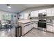 Updated kitchen featuring stainless steel appliances, white cabinets, and eat in dining with modern light fixtures at 201 W Mirror Lake Dr, Fruitland Park, FL 34731